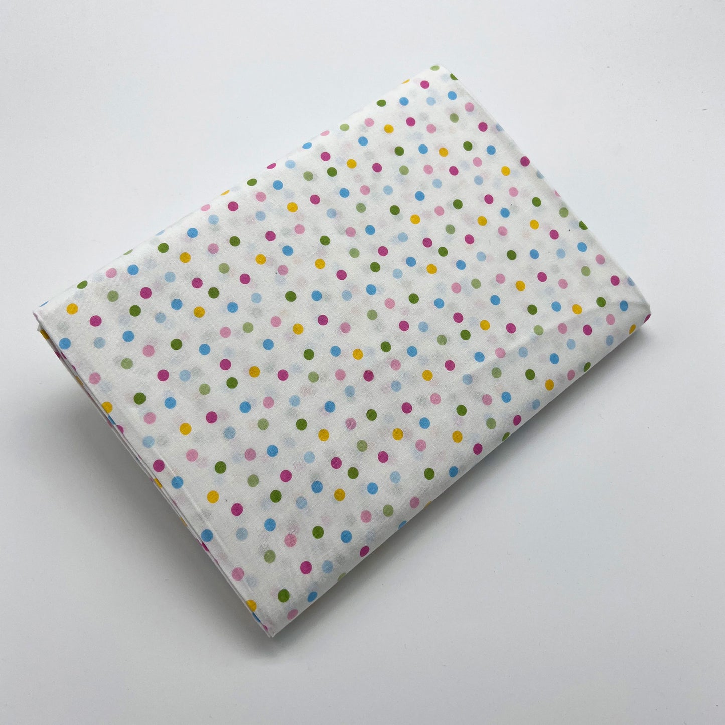 Tessuto a pois colorati su sfondo bianco
