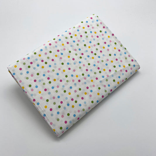 Tessuto a pois colorati su sfondo bianco