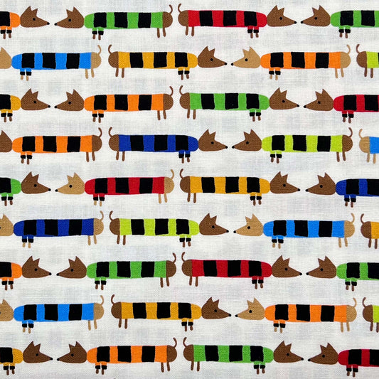 Tessuto a fantasia con bassotti colorati su fondo bianco