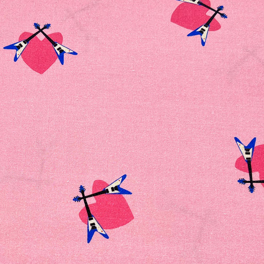 Tessuto fantasia con chitarre elettriche su fondo rosa