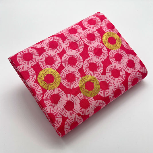 Tessuto a sfondo rosa con fantasia geometrica e dettagli oro metallizzati