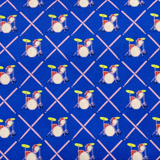 Tessuto a fantasia geometrica con batteria su fondo azzurro
