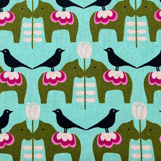 Tessuto a fantasia geometrica con animali su fondo verde acqua