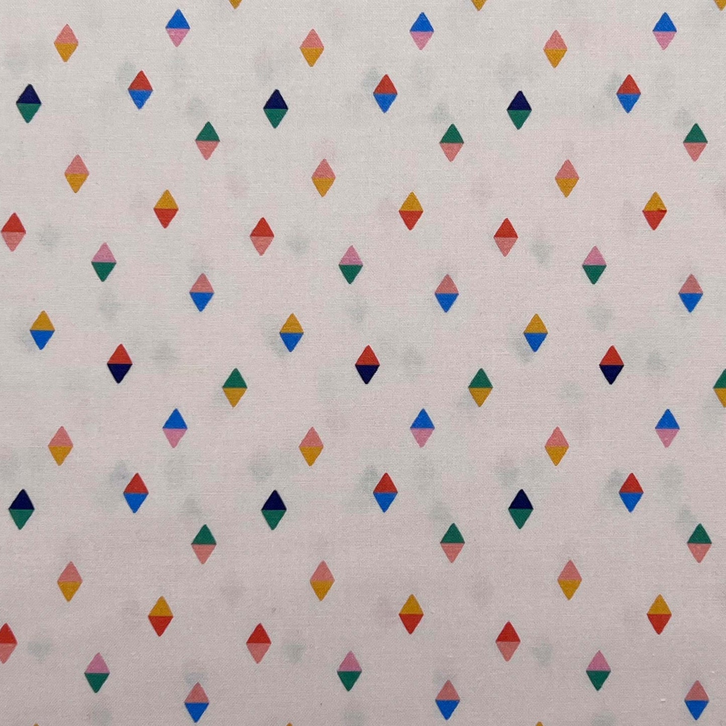 Tessuto a fantasia geometrica con piccoli rombi colorati su sfondo panna